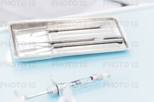 Close-up of a staminological instrument next to a metal syringe. Dental equipment. Dental hygiene