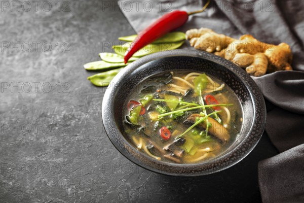 Asian vegetable soup with noodles, mushrooms, sugar peas, nori, ginger and chili, traditionally