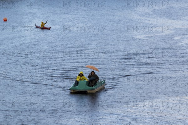 Symbolic picture weather, leisure activity, heavy rain in summer, people with umbrellas in rain