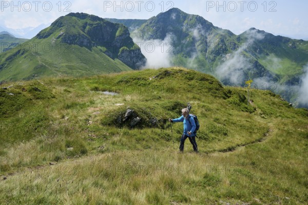 Hiker, senior climbs Saalkogel, behind Tristkogel and Gamshag, Kitzbühel Alps, Tyrol, Austria,