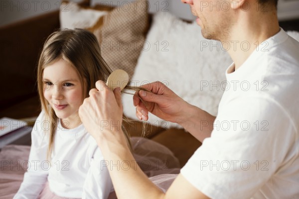 Father brushing his daughter s hair