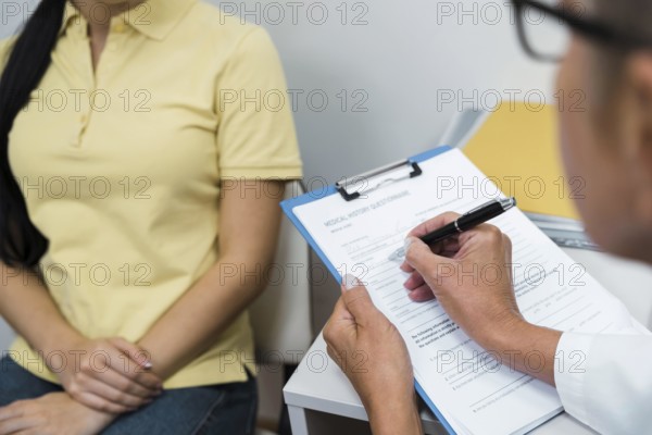 High angle doctor consulting patient her office