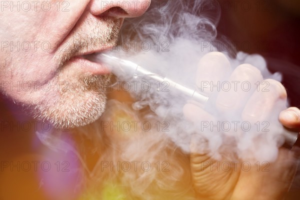 Close up portrait of a man smoking an e-cigarette