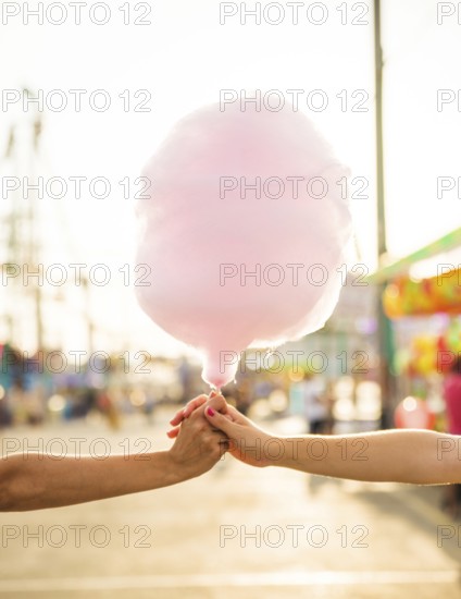 Close up two women s hand holding pink candy floss. Beautiful photo