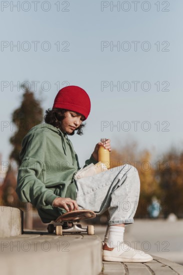 Side view teenager having lunch park skateboard