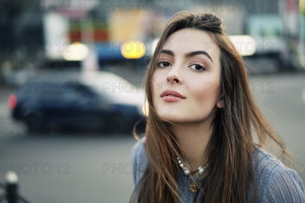 Close up young beautiful woman portrait posing in the city street in summer