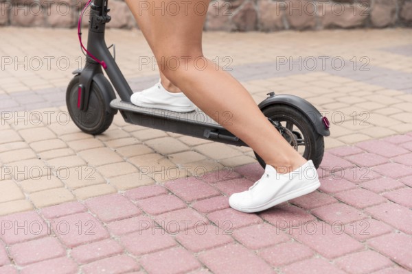 Woman using electric scooter outdoors