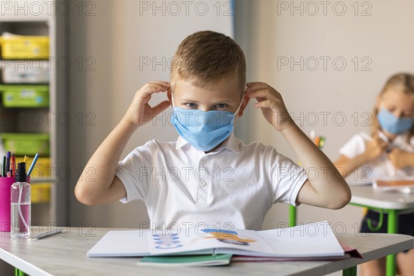 Little boy putting his medical mask