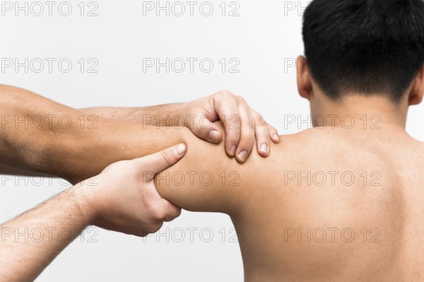 Male patient getting shoulder massage from physiotherapist