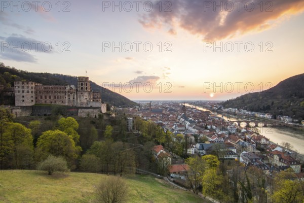 View over an old town with castle or palace rune in the evening at sunset. This town lies in a