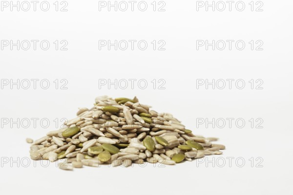 Pile of peeled pumpkin and sunflower seeds isolated on white background and copy space