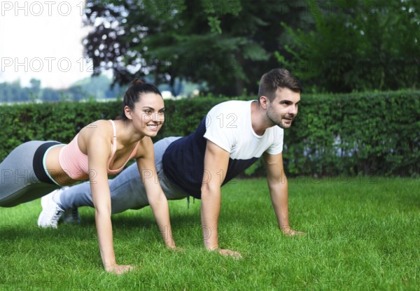 Young happpy couple exercising and stretching muscles before sport activity