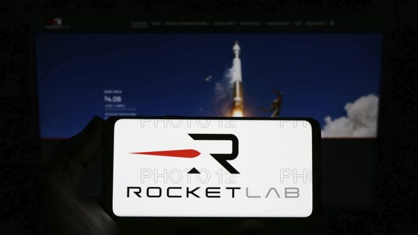 Stuttgart, Germany, 03-10-2023: Person holding smartphone with logo of aerospace company Rocket Lab
