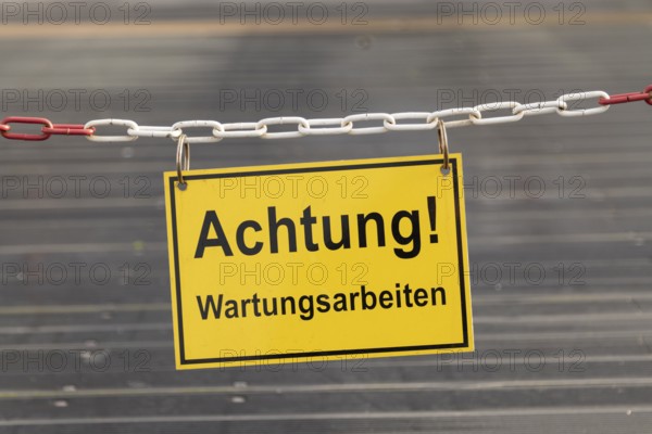 Symbolic image barrier, construction site, repair, close-up of a chain and warning sign with the