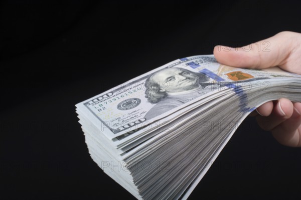 Hand holding American dollar banknotes isolated on white background