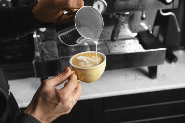 Close up hand pouring milk delicious coffee cup