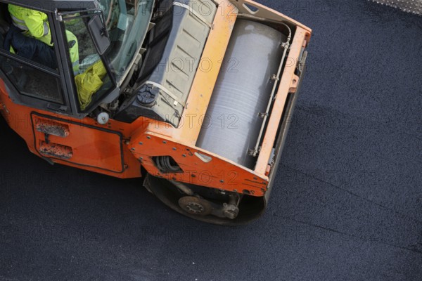 Road construction, asphalt roller press hot asphalt. Asphalt paving. High angle view