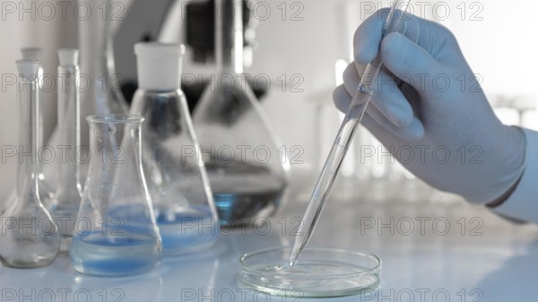 Close up hand holding lab pipette