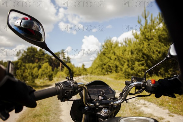 Biker riding motorbike dirt road