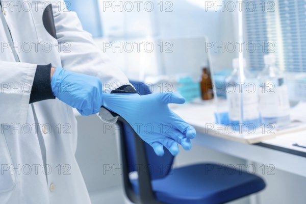 Close-up of a doctor using blue latex gloves in the laboratory of an hospital