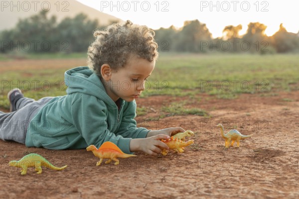 Little boy outdoors playing with toys
