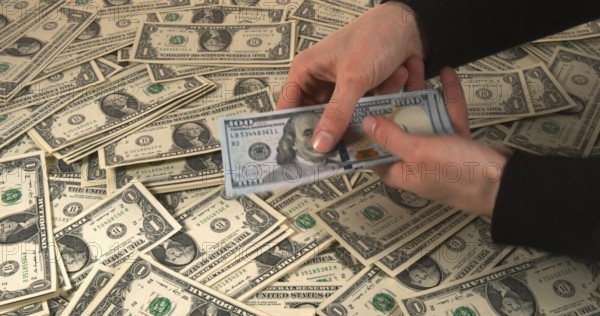 Hands of Woman and Dollar Banknotes