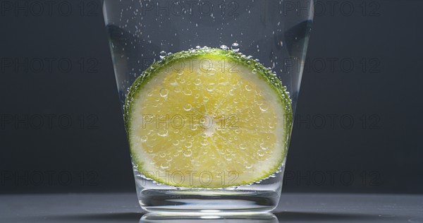 Slice of Green Lemon (citrus aurantifolia), in a Glass