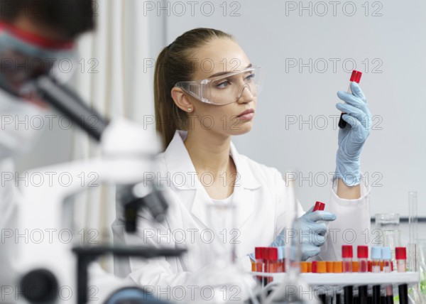 Female researcher laboratory with test tubes safety glasses male colleague