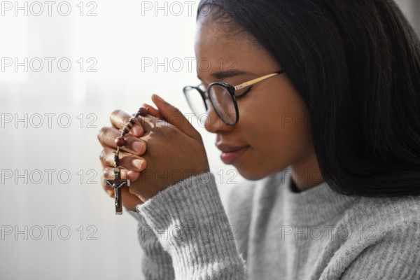 Religious woman holding rosary beads