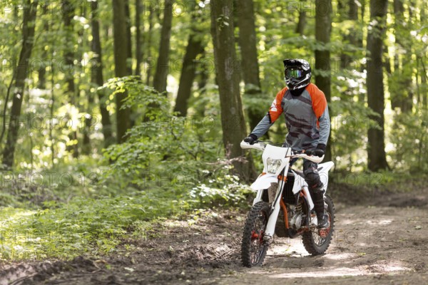 Active man riding motorcycle forrest