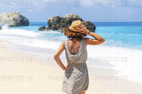 Happy woman in summer looking at the turquoise sea of Lefkada island, Ionian Sea, Greece, Europe