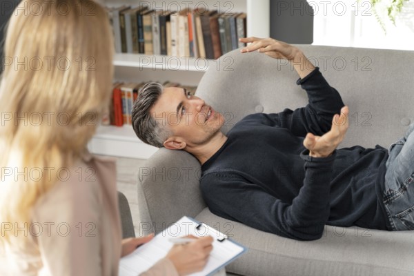 Mid shot man laying couch therapy cabinet