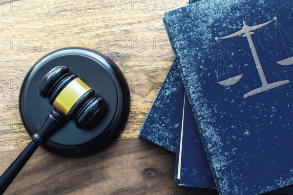 top view of judge gavel and stack of old law books with scales of justice on wooden table