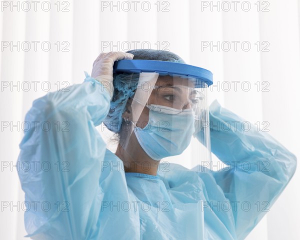 Side view woman doctor putting protective wear