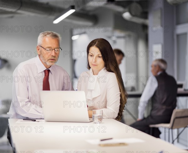 Senior businessman businesswoman looking laptop office