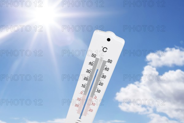 outdoor thermometer indicating high temperatures against blue summer sky and sun
