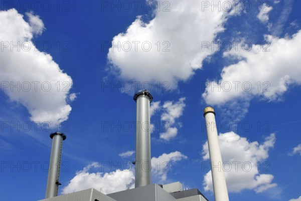Heizkraftwerk Süd in Munich, a power plant with three chimneys, white clouds in blue sky seem to