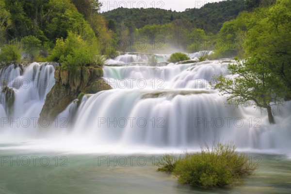 A quiet, gentle waterfall in the middle of a green, wooded landscape, Krka National Park, Krka