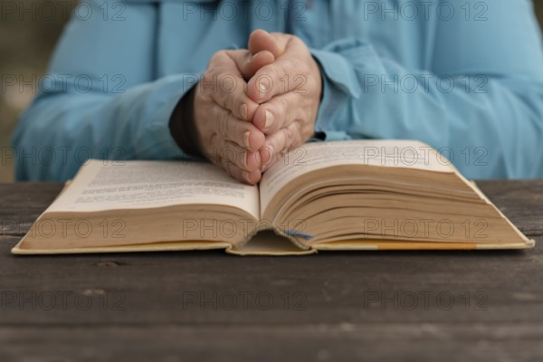 Woman with her hands on top of a holy book in prayer posture