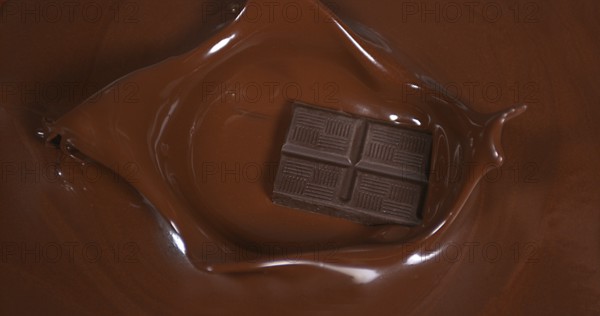 Black Chocolate tablet falling into Milk Chocolate