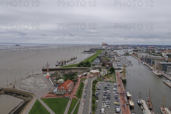 Panoramic view of a harbour town with a long dyke, streets and individual buildings along the