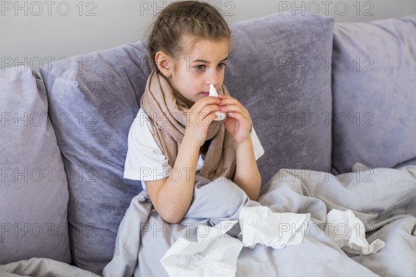 Little girl using nose spray