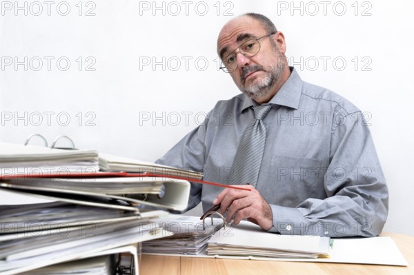 An arrogant civil servant sits behind his desk