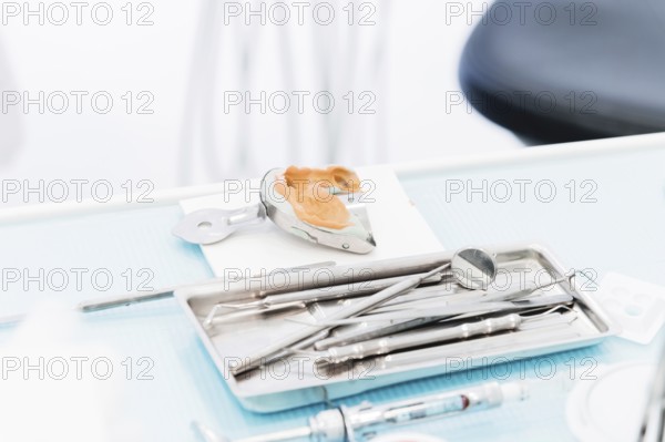 Close-up of a common stamotological instrument next to a metal form for prosthetics. Dental