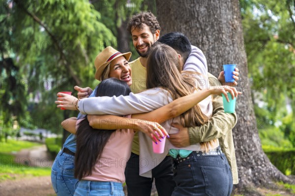 Multiethnic group of birthday party in the city park embraced in a symbol of friendship forever