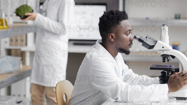 Side view male researcher laboratory with microscope