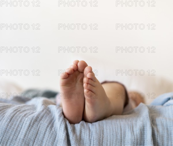 Close up baby feet sitting bed