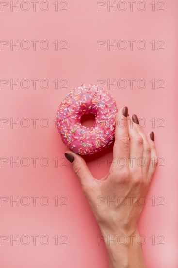 Top view hand holding donut