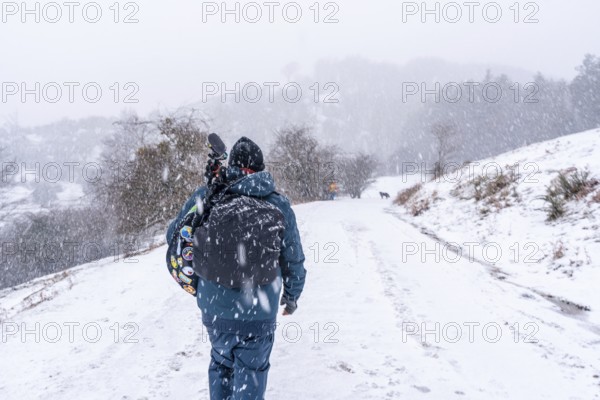 A young photographer walking in the aizkorri mountain of gipuzkoa. Snowy landscape by winter snows.