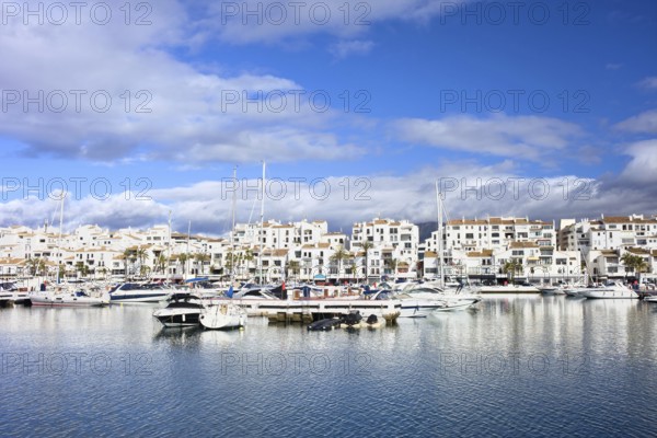 Marina waterfront with luxury motor yachts in holiday resort town of Puerto Banus on Costa del Sol,